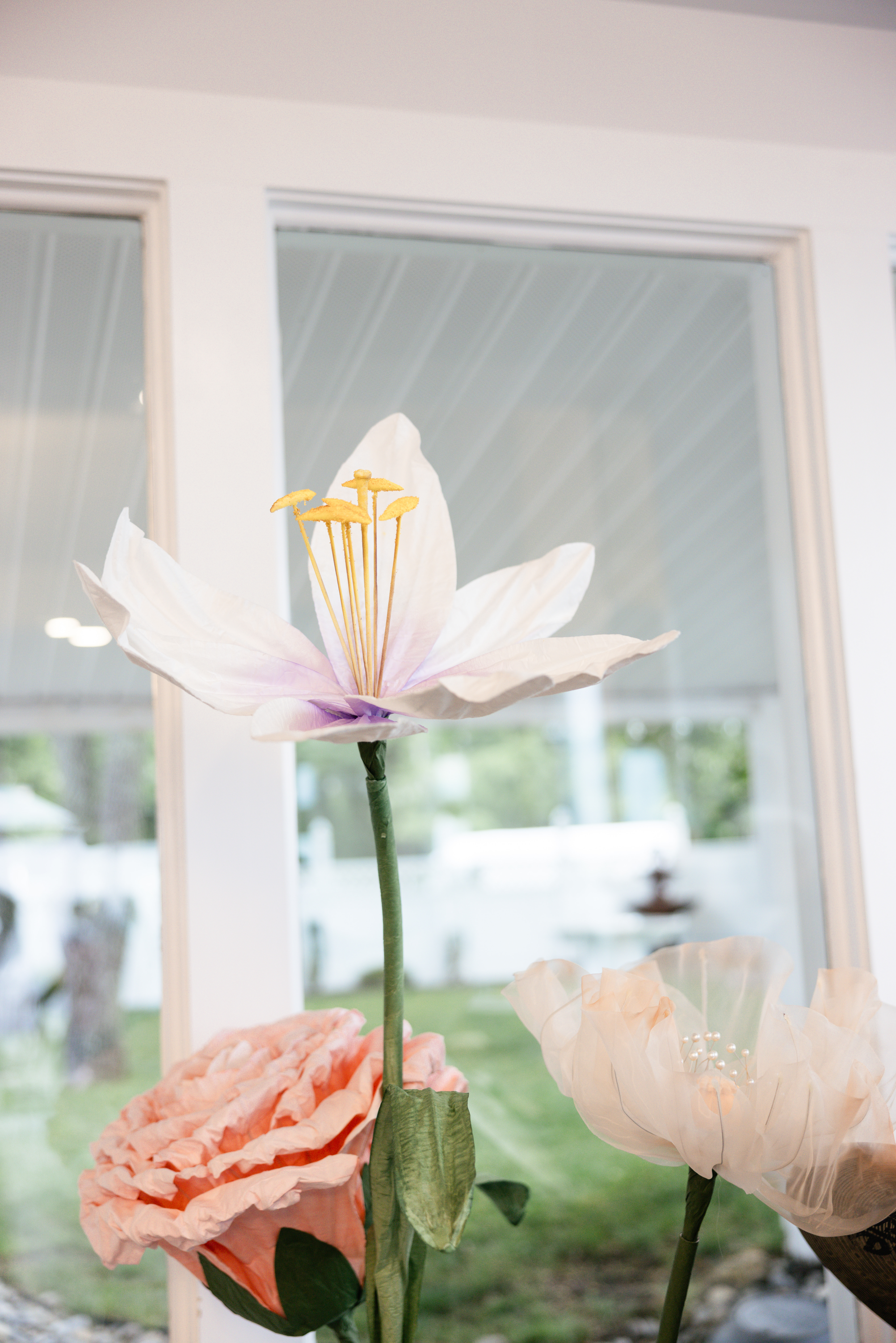 Large flower props in white pink and light pink in a corner of a room.
